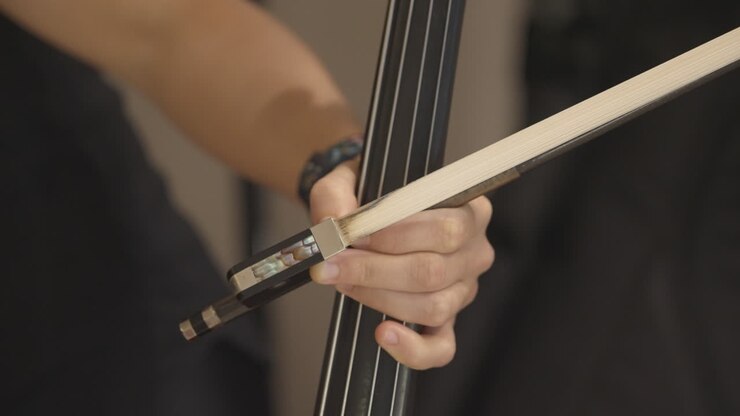 Close-up of Musician's Hand Playing Cello Strings with a Bow
