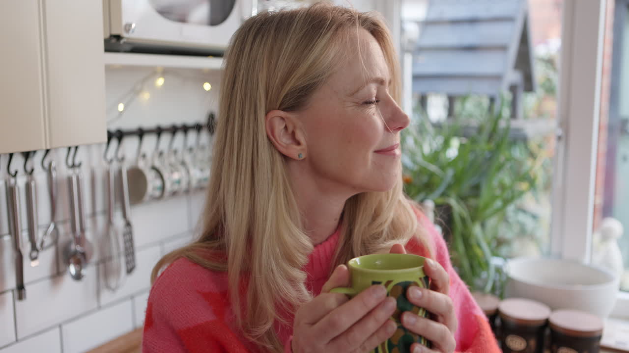 A woman drinking coffee in the kitchen