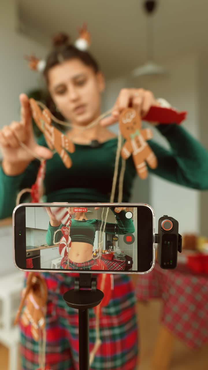 Woman recording a Christmas DIY tutorial on her smartphone