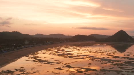 The-dry-reef-of-Kuta-Lombok-during-sunrise,-with-local-people-looking-for-food-and-seashells