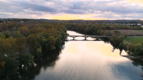 phoenixville schuylkill river 4k drone in golden hour during fall autumn flying over river into sunlight