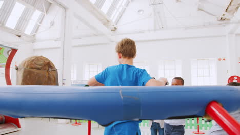 los niños miran a un niño en un experimento centrífugo en un centro de ciencias.