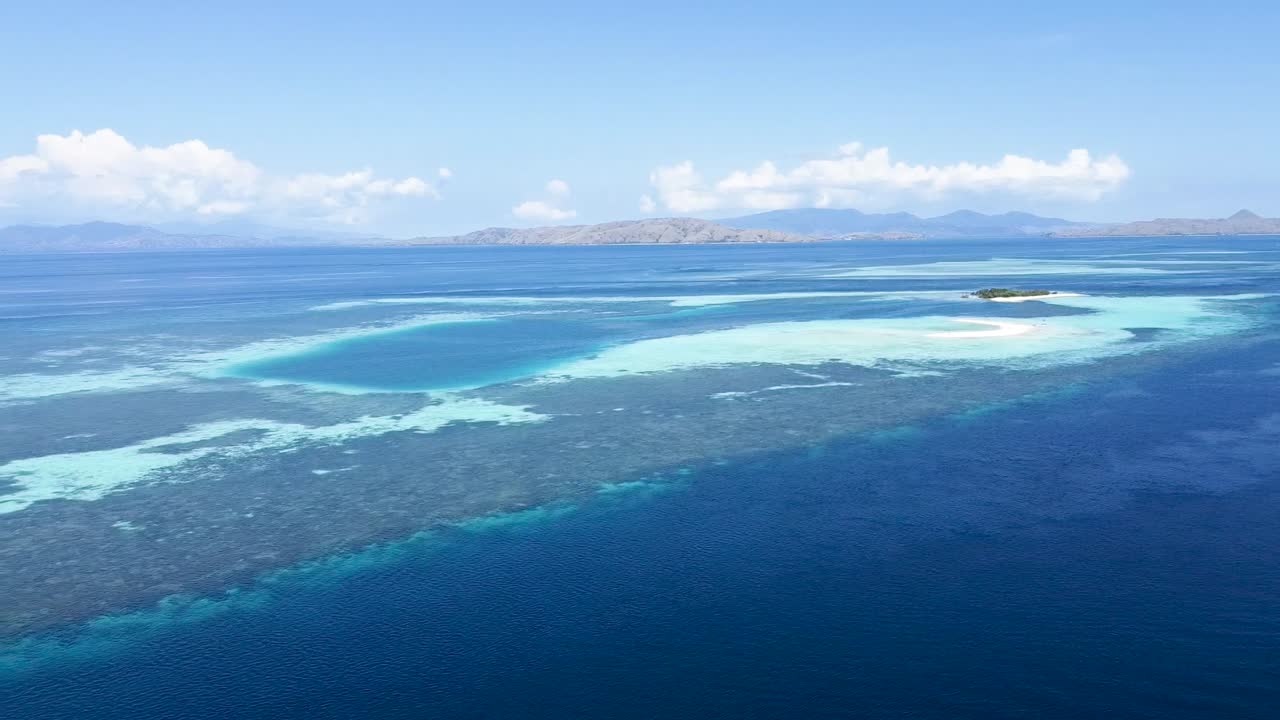 팔루아우 카탕안 샌드뱅크 산호초는 곡선형 해변이 있는 인도네시아 코모도 섬 동쪽의 환초, 공중 돌리 아웃 공개 샷