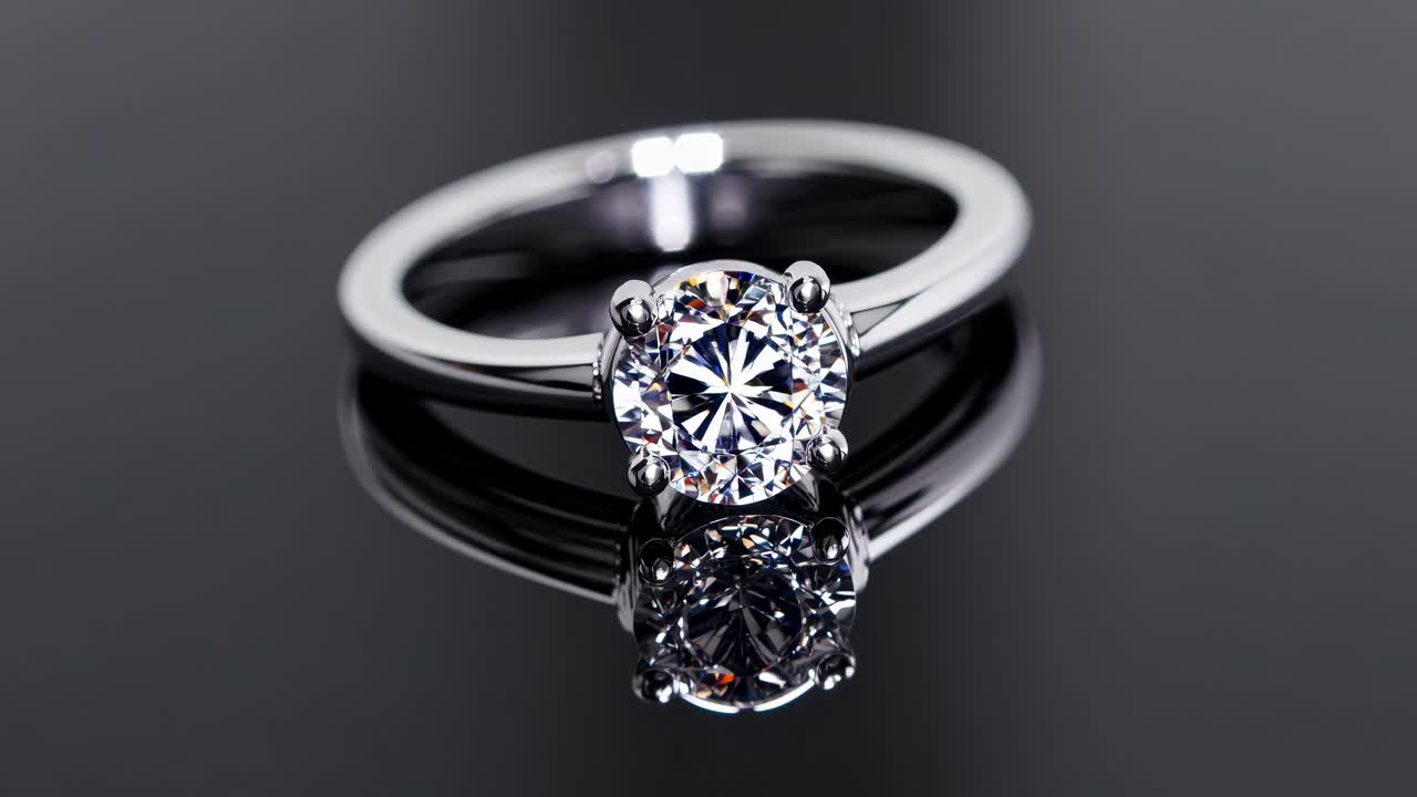 Inquadratura video ravvicinata di un anello di diamante scintillante su una superficie nera riflettente.