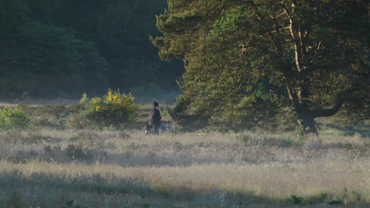Donna in bicicletta in campagna, rallentatore.