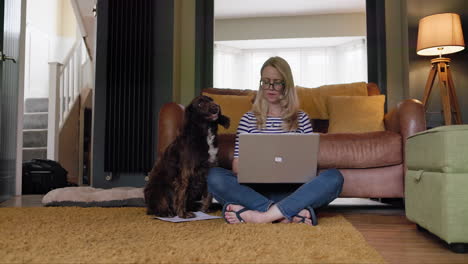 mujer trabajando desde casa con su perro