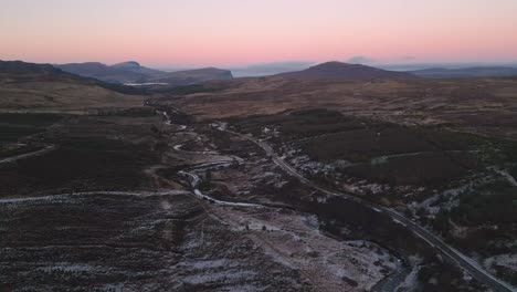 Camino-Sinuoso-En-El-Paisaje-Accidentado-De-Skye-Durante-El-Crepúsculo,-Vista-Aérea