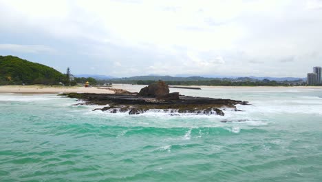 Mar-De-Fondo-Golpeando-La-Costa-Rocosa---Playa-De-Currumbin-Y-Formación-Rocosa-Durante-El-Día-En-Queensland,-Australia