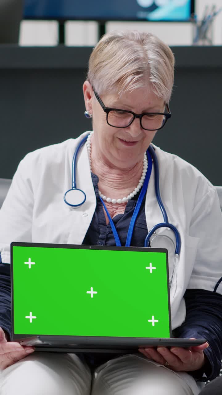 Dottore con laptop che mostra uno schermo verde