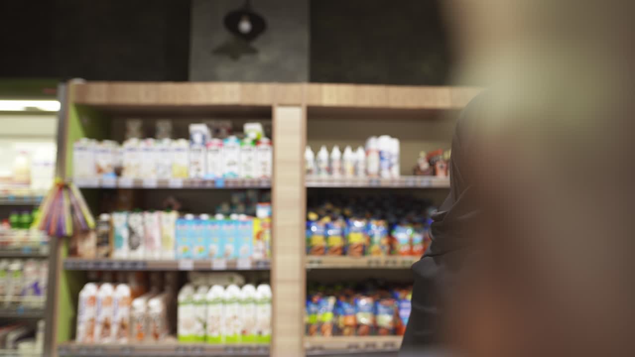 mujer con hijab y máscara protectora toma el producto del estante, imágenes del interior