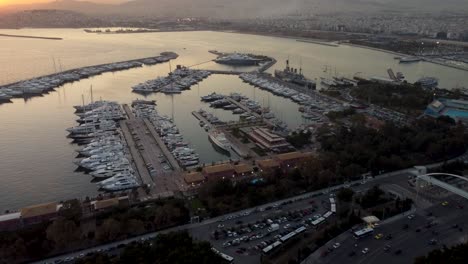 an stunning drone shot of approaching the floisvos marina during a beautiful sunset in athens, greece