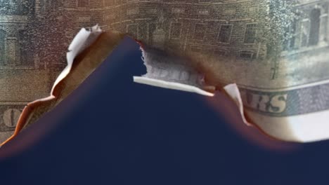 flame burns through the center of a usa 100 dollar bill, economy collapse concept