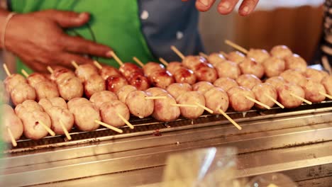 grilled thai sausage skewers at a street market