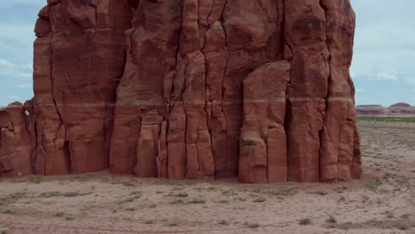 geological layers of sandstone rock in standing cliff rock formation in arizona desert - aerial pullaway