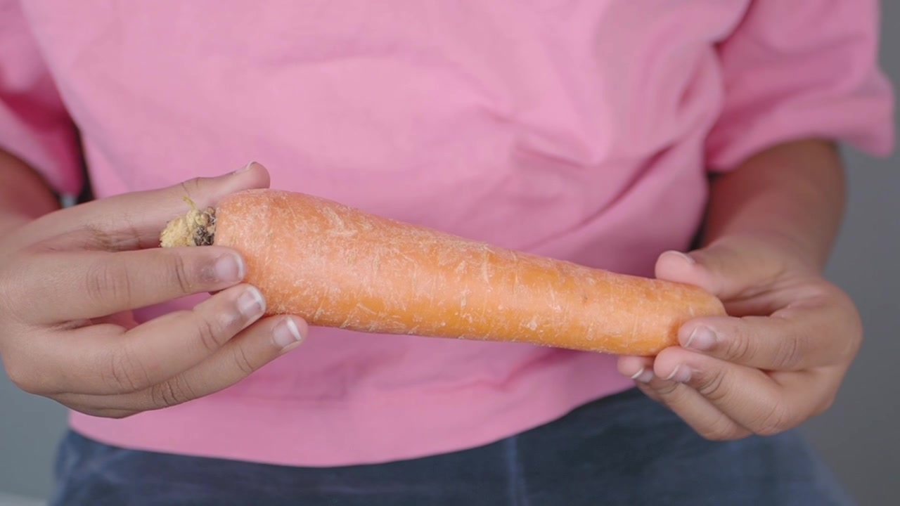 Person Holding a Fresh Raw Carrot