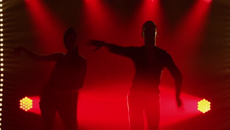 dynamic dance silhouettes under dramatic red lighting