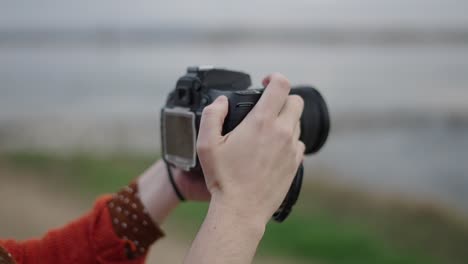 person taking a picture with a dslr camera outdoors