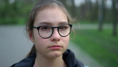 Porträt-Eines-Ernsthaften-Mädchens,-Das-Im-Park-Bleibt.-Teenager-Mädchen-Schaut-Draußen-In-Die-Kamera.