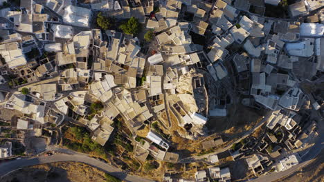 venetian castle and chora village traditional houses flat rooftops at sunrise, amorgos island, overhead drone shot