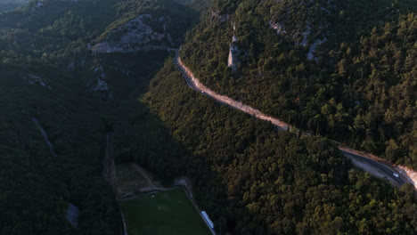 vista aérea rastreando coches en un camino de la ladera de la montaña, soleado, noche de verano en croacia