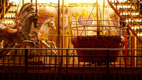 carousel roundabout or merry-go-round with colourful horses and retro vintage wooden seat