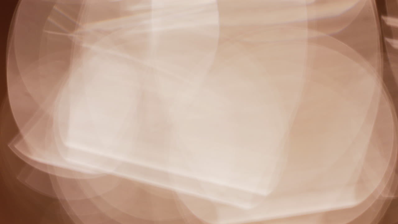 Abstract composition of light trails and overlapping bokeh in warm golden tones