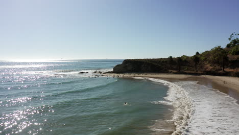 Sunlight-glittering-on-peaceful-beach-on-California-coast,-Aerial-View