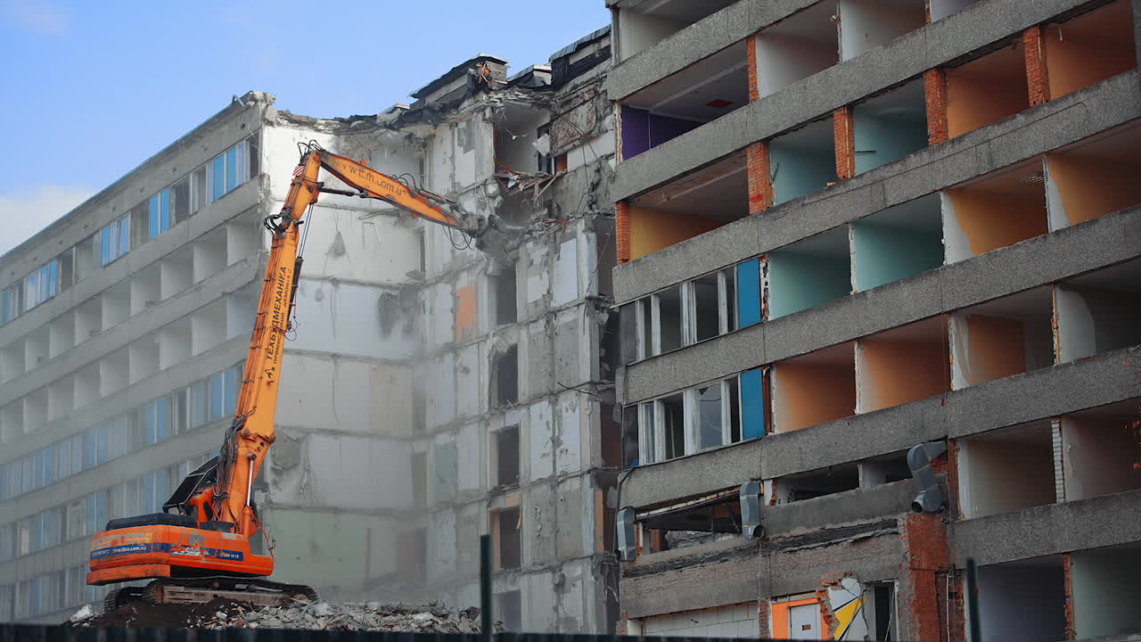 Demolition of the old multi flat house. House being demolished by special machinery.