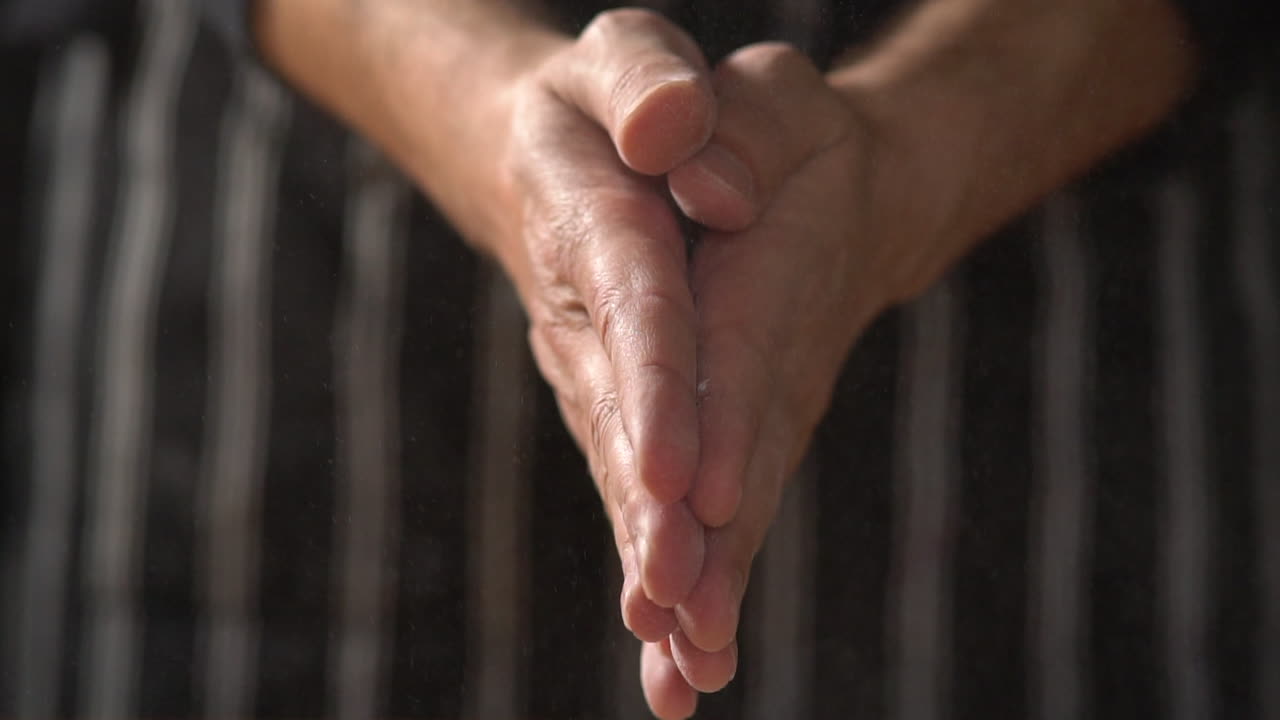 cu cámara lenta: el chef masculino con delantal aplaude, la harina vuela por el aire y luego se frota las manos