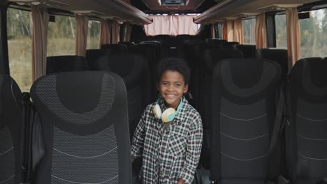 portrait of happy boy in empty bus