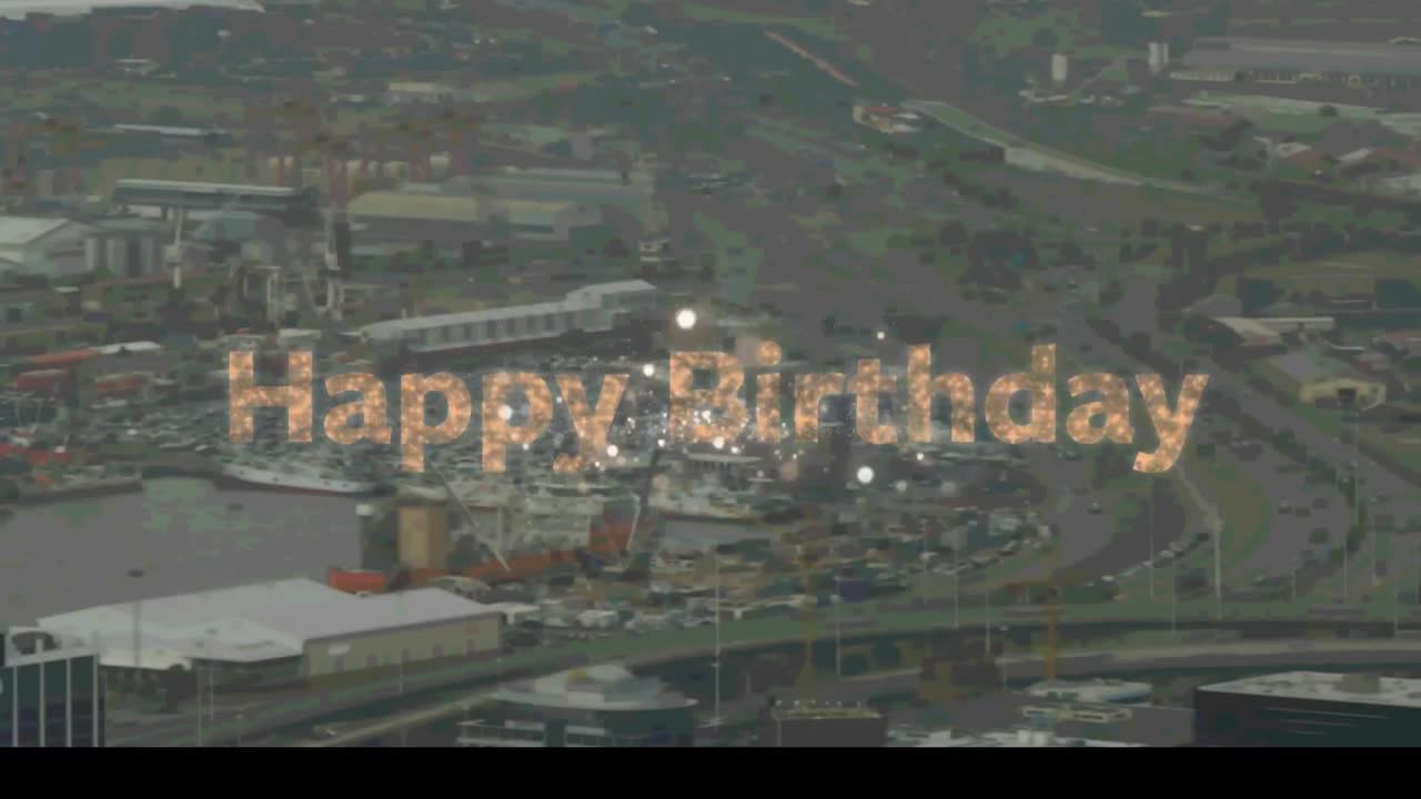 текст с днем рождения над фейерверками, взрывающимися на фоне воздушного вида городского пейзажа