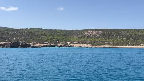 sailing boat in the large blue sea near the coastline of the long island in hot weather