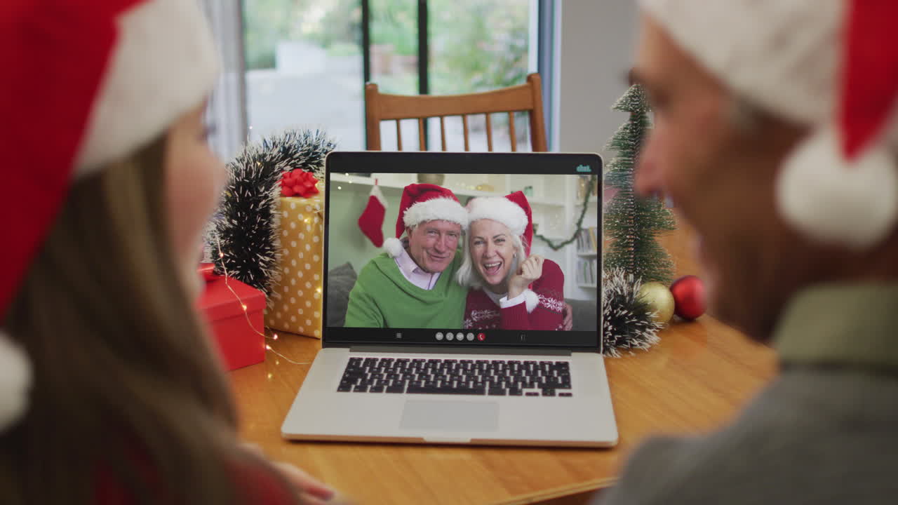 feliz pareja de ancianos caucásicos en videollamada con amigos mayores en tiempo de navidad