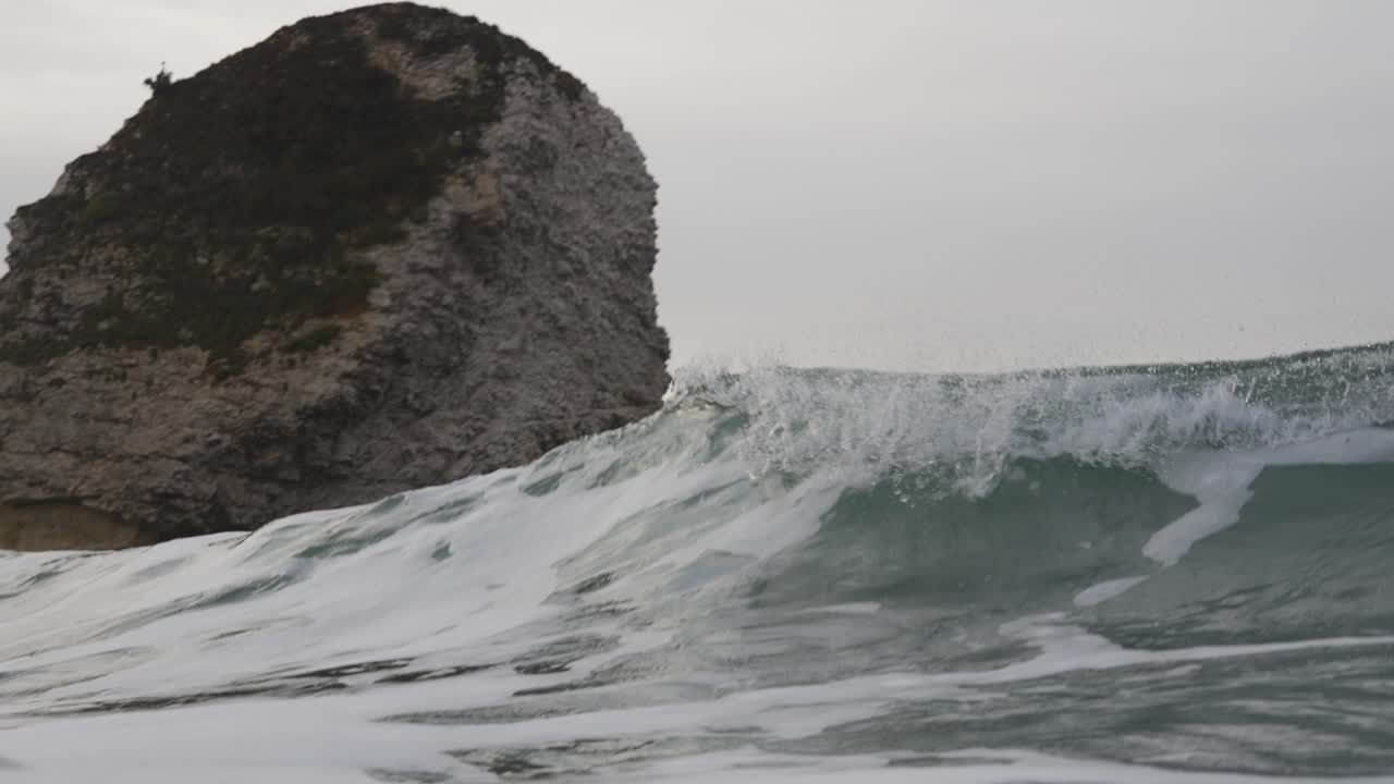 큰 바위 앞에 파도가 부 ⁇ 히고