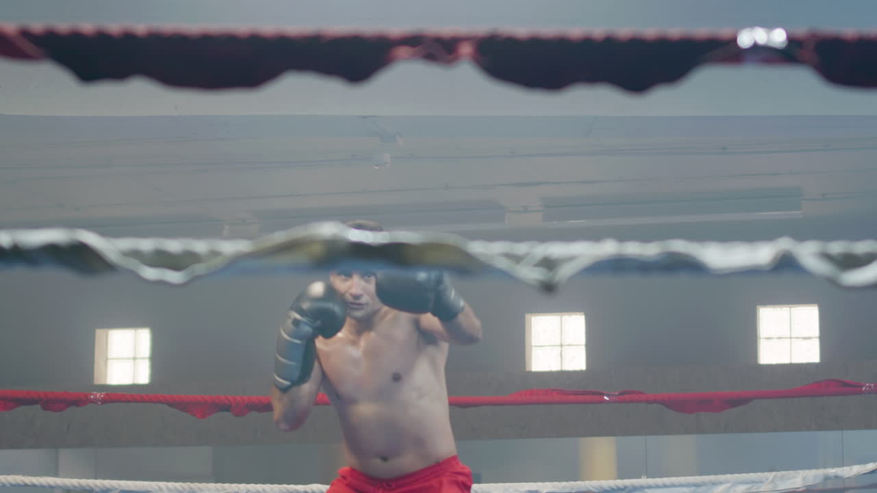 молодой боксер, сражающийся в тени в боксерском зале.