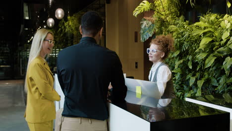 redheaded receptionist sitting behind the counter of a hotel