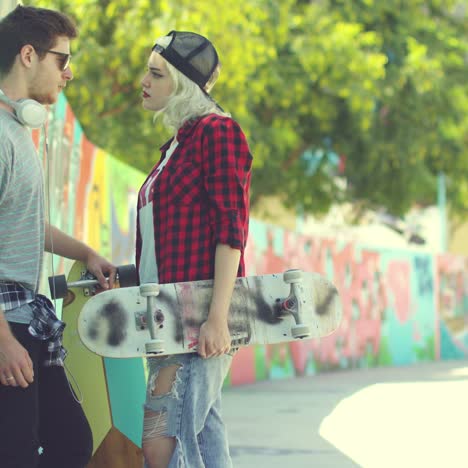 Trendy-young-couple-chatting-in-an-urban-street