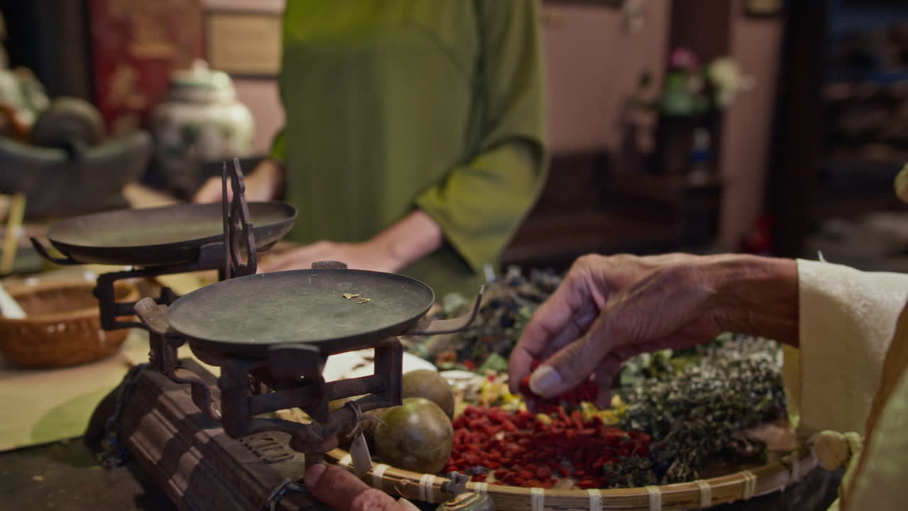 Hands of Asian Healer Using Scales when Preparing Herbal Mixture