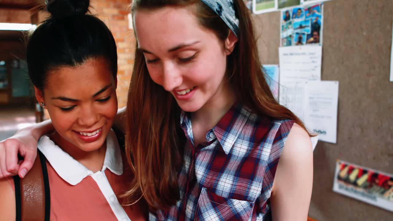 통로에서 휴대폰을 사용하는 여학생들