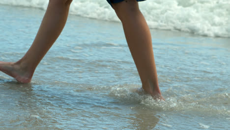 Unterer-Abschnitt-Eines-Mannes,-Der-Am-Strand-Auf-Dem-Meer-Spaziert,-4k