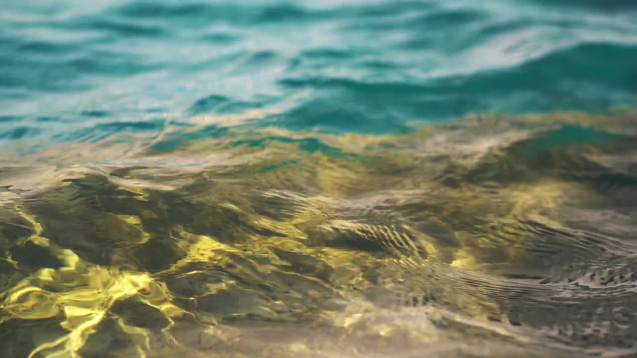 Slow-motion, close-up of water surface ripples on an outdoor swimming pool.
