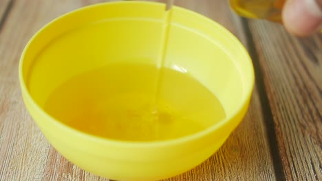 pouring oil into a yellow bowl