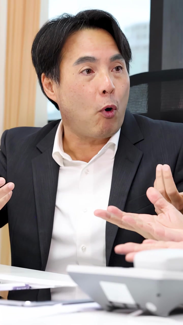 Middle-aged businessman reacts emotionally during intense office meeting, gesturing expressively in bright conference room