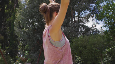 Mujer-Caucásica-Sonriente-Con-Los-Brazos-En-El-Aire-Practicando-Yoga-En-El-Parque