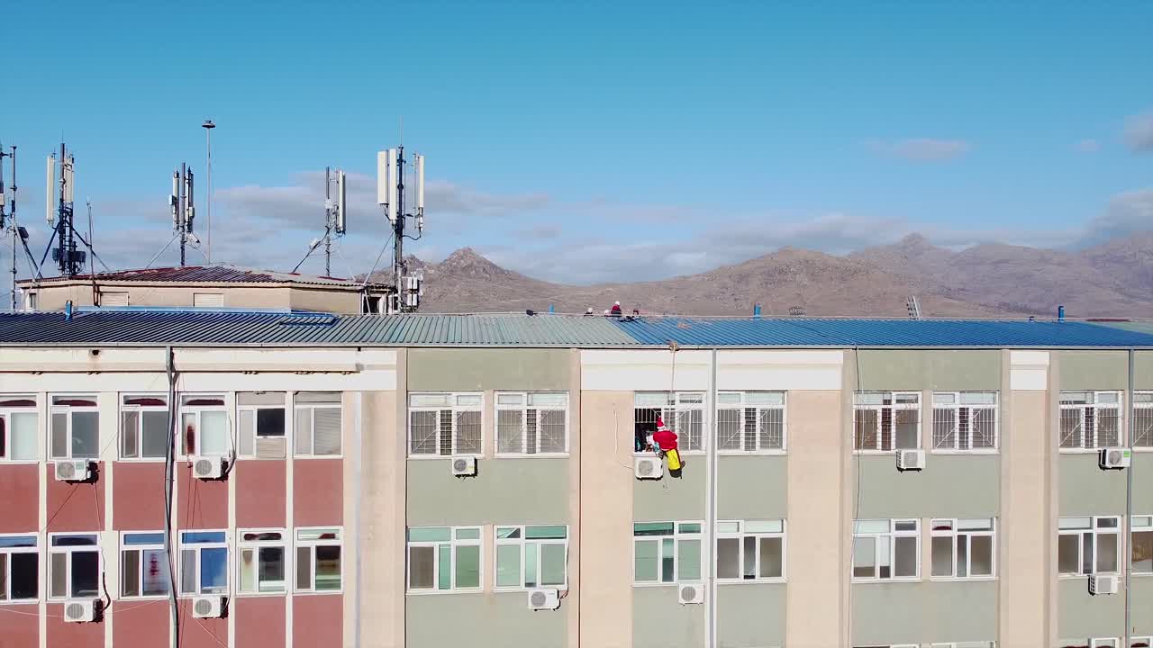 아픈 아이들을 놀라게 하는 병원 창문에 들어가는 산타클로스