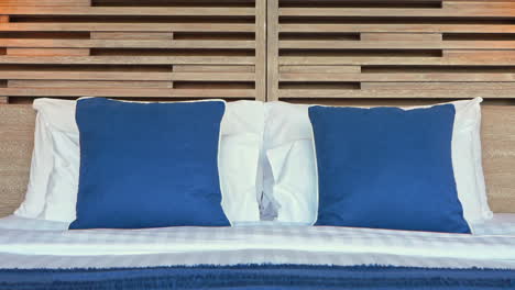 luxury bed in bedroom of exotic tropical resort blue and white pillows, close up