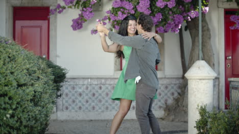 happy young couple spending time in park, dancing and kissing.