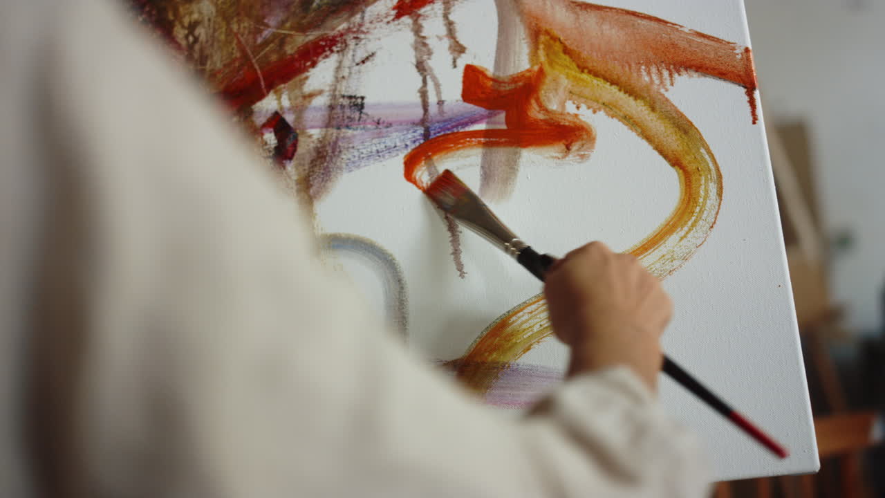 pintora desconocida haciendo pinceladas en el interior. artista femenina trabajando en el estudio.