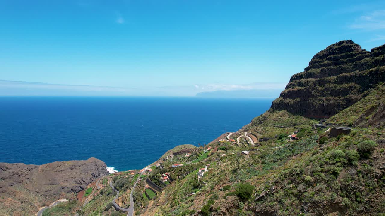 la isla de la gomera, españa: una vista aérea de una carretera curva que serpentea a través de altos picos montañosos con el océano en el fondo, españa