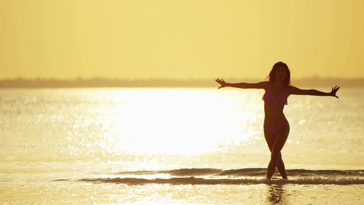 해가 지는 해변에 있는 젊은 아시아 중국인 소녀